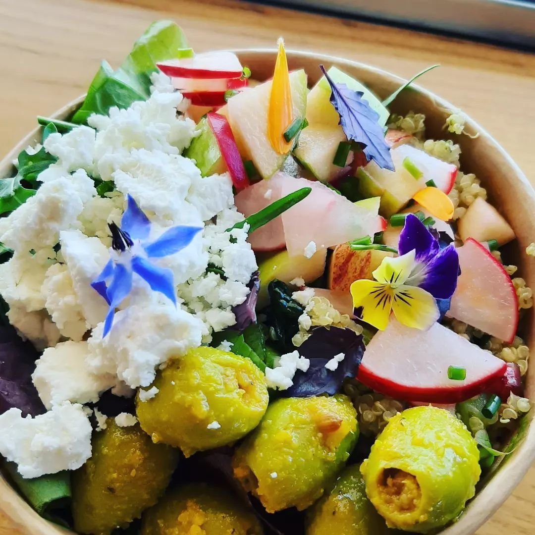 A garden salad with feta, olives and edible flowers