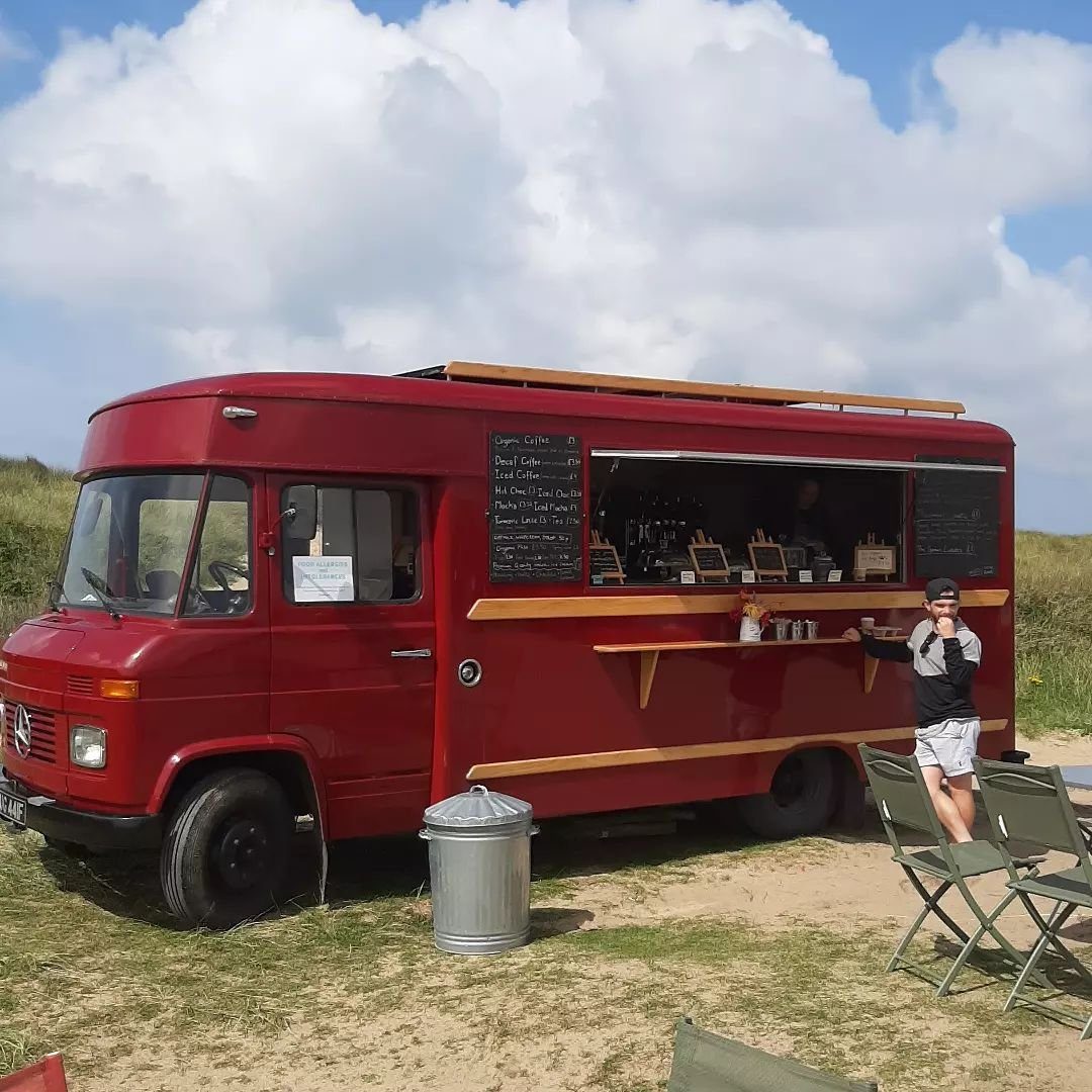 The red Dreamboat van parked at the beach