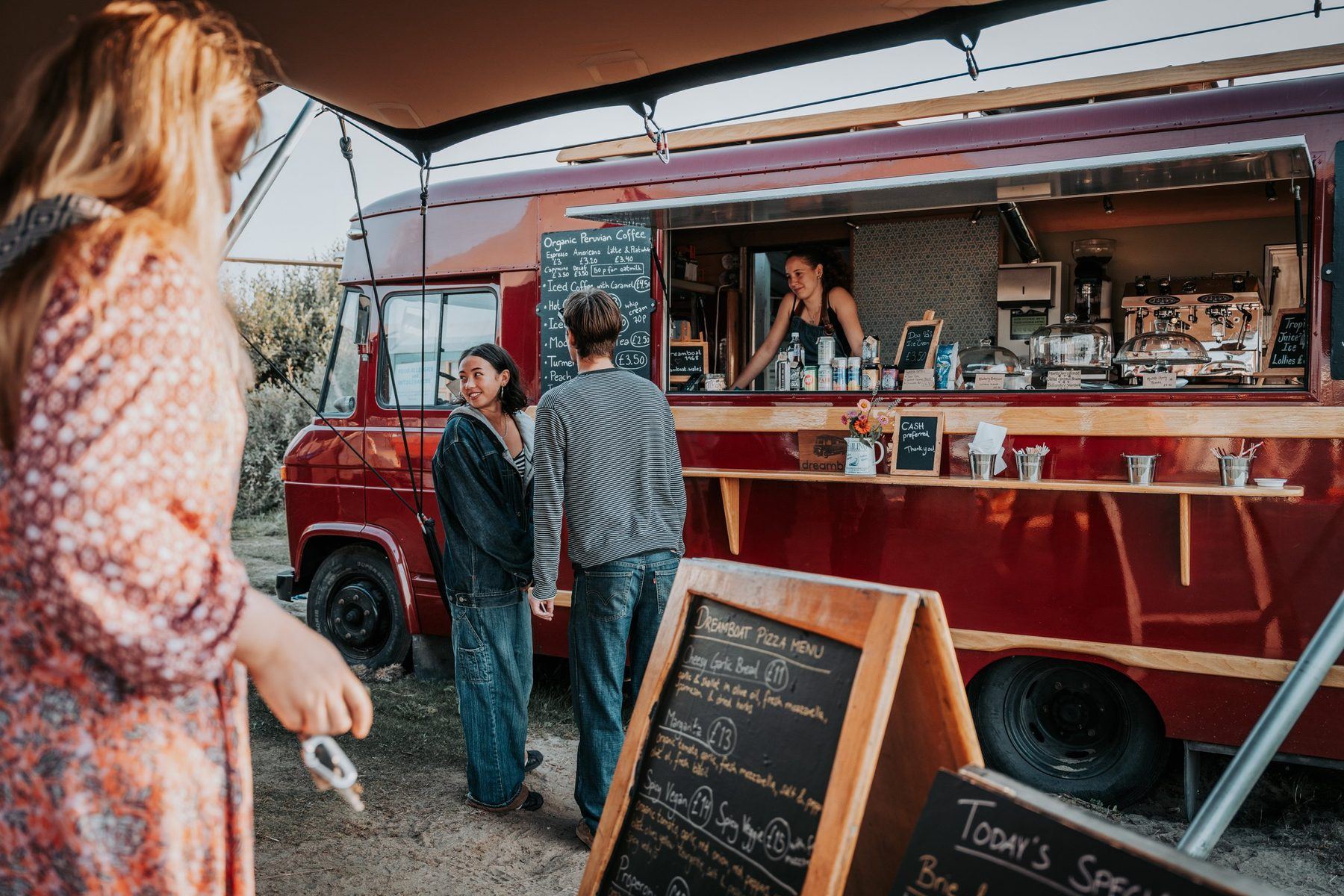 Customers being served at the hatch of the restored red 1968 Mercedes van